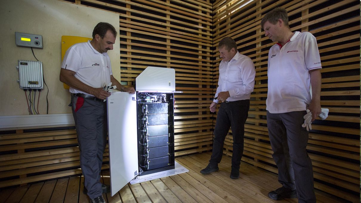 Alexander Kupfer (center) from Sustainable Product Development at Audi explains how the battery storage system works. The system supplies the measurement technology with energy locally in the oak forest. Also pictured: Albert Mayer, Audi plant manager at the Ingolstadt site (left) and Dr. Rüdiger Recknagel from the Audi Environmental Foundation (right).