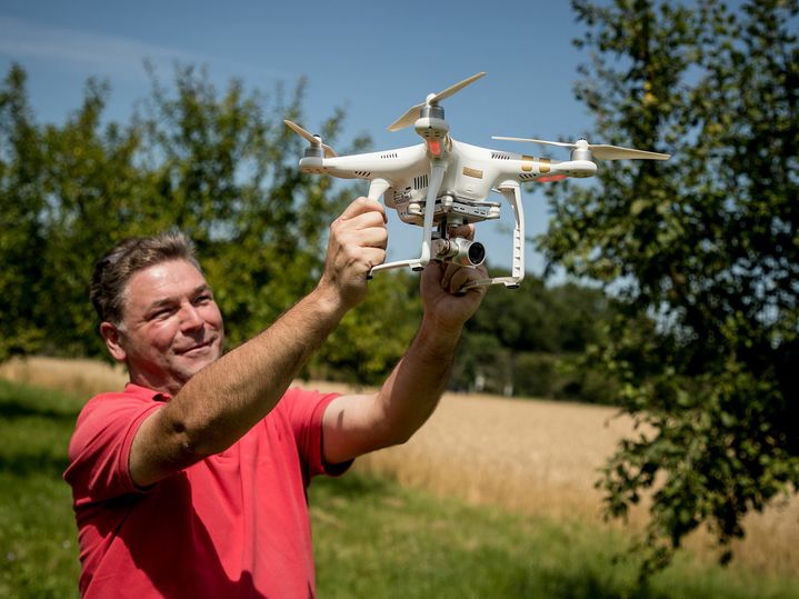 Geomonitoring Mann hält Drohne fest